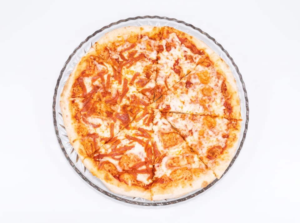 A whole cheese pizza with tomato sauce, cut into slices, on a clear glass plate.