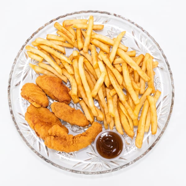Golden french fries, crispy chicken tenders, and a small cup of barbecue sauce on a clear plate.