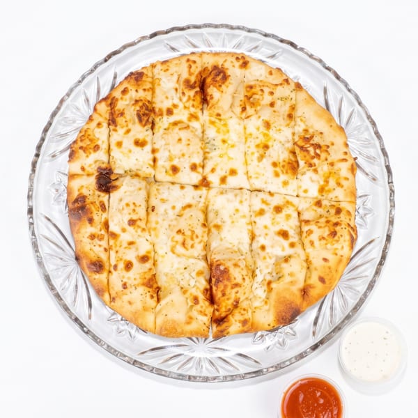 Cheesy garlic breadsticks on a clear glass plate with marinara and ranch dipping sauces.