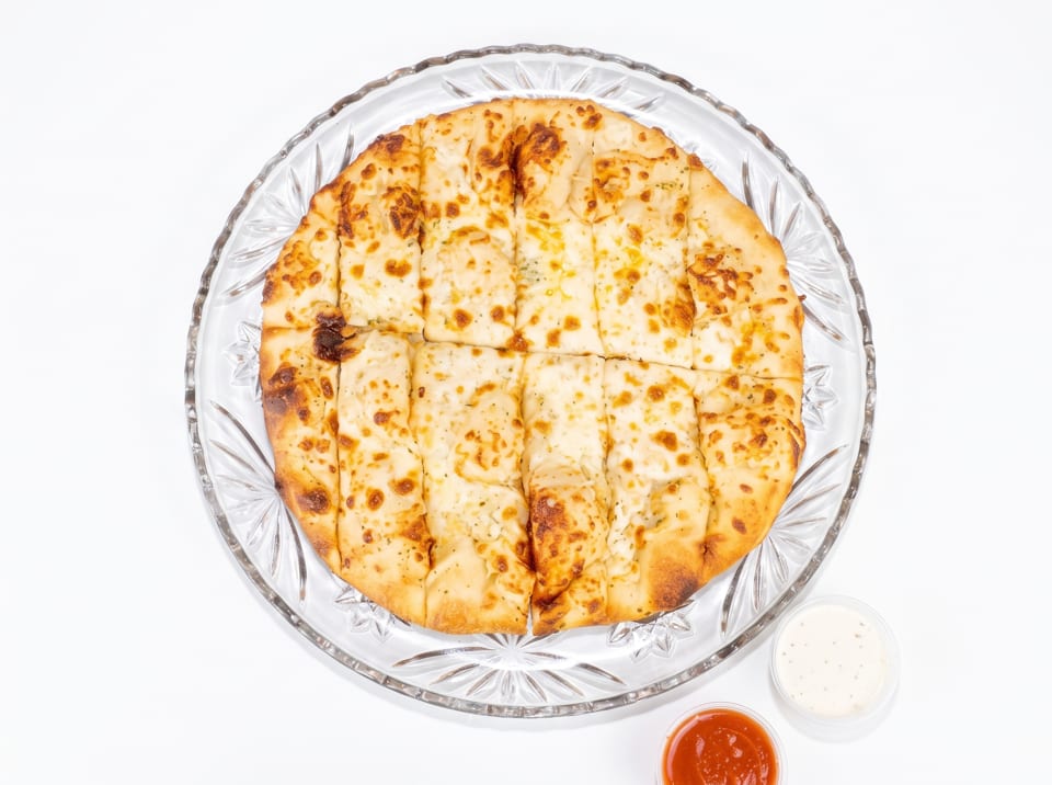 Cheesy garlic breadsticks on a clear glass plate with marinara and ranch dipping sauces.